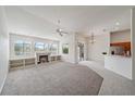 Open living room with fireplace and built in shelves overlooking the pool and lake at 6552 Meandering Way, Lakewood Ranch, FL 34202