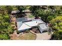 An aerial view showing a home with an in-ground pool, screened lanai, and a metal roof at 6990 Richardson Rd, Sarasota, FL 34240