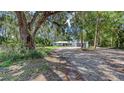 Charming home featuring a shell driveway and mature trees offering privacy and curb appeal at 6990 Richardson Rd, Sarasota, FL 34240
