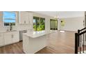 Modern kitchen with white cabinets, island with bar seating, and adjoining open-concept living space at 7533 Nighthawk Drive, Sarasota, FL 34241