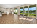 Bright living room with wood floors and sliding glass doors offering a picturesque pond view at 7533 Nighthawk Drive, Sarasota, FL 34241