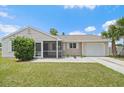 Charming single-story home featuring a screened porch, attached garage, and manicured lawn at 7595 Berwick St, North Port, FL 34287