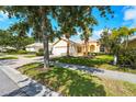 Charming home with manicured landscaping, mature trees, and a brick driveway in a quiet residential neighborhood at 7716 Uliva Way, Sarasota, FL 34238