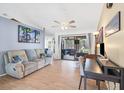 Bright living room showcasing a comfortable couch, ceiling fan, and sliding glass doors to the lanai at 7834 38Th E Ct, Sarasota, FL 34243