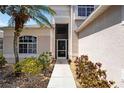 A well-lit walkway leading up to the front door, surrounded by mature landscaping and decorative gravel at 8222 Haven Harbour Way, Bradenton, FL 34212