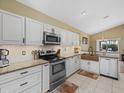 Updated kitchen with stainless steel appliances, granite countertops, white cabinets, and a copper sink at 8222 Haven Harbour Way, Bradenton, FL 34212
