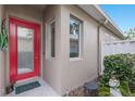 Inviting front entrance with a bright red door and charming decorative accents at 8706 52Nd E Dr, Bradenton, FL 34211