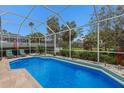Sparkling screened-in pool with lush landscaping and a sunny outdoor area at 8706 52Nd E Dr, Bradenton, FL 34211