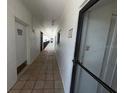 Hallway of building featuring tiled floor and doors to units and laundry room access at 8977 Midnight Pass Rd # 521, Sarasota, FL 34242