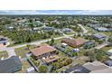 An aerial view showcasing a residential neighborhood with lush greenery and varied home styles at 9089 Berendo Ave, Englewood, FL 34224
