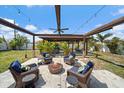 Inviting backyard patio space with comfortable seating, ambient lighting, and a cozy stone fire pit at 9089 Berendo Ave, Englewood, FL 34224