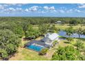 Private home with a screened-in pool surrounded by lush greenery at 919 Palm View Way, Sarasota, FL 34240