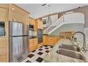 Stylish kitchen featuring stainless steel appliances, light wood cabinets and black and white flooring at 919 Palm View Way, Sarasota, FL 34240