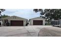 Single-story home features a long driveway to the garage, a trailer, and landscaping at 1016 Rhodes Ave, Sarasota, FL 34237