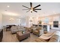 Open-concept living room with a large ceiling fan, recessed lighting, and access to the kitchen at 11427 Viani Ter, Palmetto, FL 34221