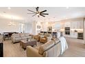 Open-concept living room with a large ceiling fan, recessed lighting, and access to the kitchen at 11427 Viani Ter, Palmetto, FL 34221