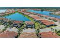 An aerial view showcasing beautiful waterfront homes in a well-planned community with scenic lakes and landscaping at 121 Porta Vecchio Bnd # 201, Nokomis, FL 34275