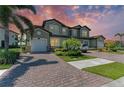 A spacious two-story home with a brick driveway, well-maintained landscaping, and a two-car garage at 121 Porta Vecchio Bnd # 201, Nokomis, FL 34275