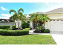 Inviting home exterior featuring a well-maintained lawn, lush landscaping, and a convenient two-car garage at 12358 Lavender Loop, Bradenton, FL 34212