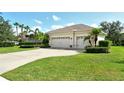 Exterior view of a home showcasing a spacious driveway leading to a three-car garage and landscaped yard at 12358 Lavender Loop, Bradenton, FL 34212