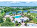 Aerial view showcasing the community pool and splashpad, alongside a scenic lake and surrounding residential area at 12755 Rainwashed Loop, Parrish, FL 34219