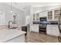 Well-lit kitchen featuring stainless steel appliances, white cabinetry, granite countertops, and stylish backsplash at 12755 Rainwashed Loop, Parrish, FL 34219