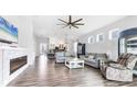 Open living room with tile flooring, contemporary furniture, fireplace, and views into the kitchen and dining areas at 12755 Rainwashed Loop, Parrish, FL 34219