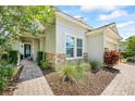 Home exterior displaying a stone accent wall, brick walkway, and beautiful landscaping at 13819 American Prairie Pl, Bradenton, FL 34211