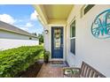 Cozy front porch features brick pavers, a blue door with wreath, and bench seating at 13819 American Prairie Pl, Bradenton, FL 34211
