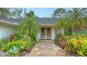 Up close, front entrance featuring a stone path and lush landscaping at 1610 S Orange Ave, Sarasota, FL 34239