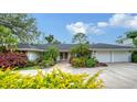 Charming home front exterior showing the pink double front doors, landscaped yard, and a long driveway at 1610 S Orange Ave, Sarasota, FL 34239