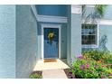 Inviting front door adorned with a wreath and surrounded by colorful flowers and greenery at 1721 Palm Warbler Ln, Ruskin, FL 33570