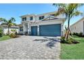Charming two-story home with blue garage doors and a paved driveway at 17723 Palmiste Dr, Bradenton, FL 34202