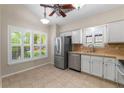 Sunlit eat in kitchen with tile flooring, stainless steel appliances, and white cabinets at 1869 Springbush Ln, Clearwater, FL 33763