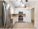 Bright kitchen featuring stainless appliances, white cabinetry, and tile flooring at 1869 Springbush Ln, Clearwater, FL 33763