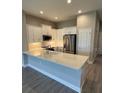 Well-lit kitchen featuring white cabinetry, stainless steel appliances, and a quartz countertop bar at 24779 Buckingham Way, Port Charlotte, FL 33980