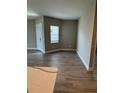 Living room with wood-look tile, a front door entrance, and plenty of natural light at 24831 Buckingham Way, Port Charlotte, FL 33980