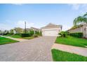 Beautifully landscaped single-story home with a paver driveway and a two-car garage at 2625 Star Apple Way, Sarasota, FL 34240