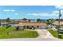 Inviting single-Gathering home showcasing a lush lawn, mature landscaping, and well-maintained exterior at 264 E Tarpon Nw Blvd, Port Charlotte, FL 33952