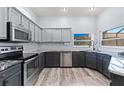 Modern kitchen with gray cabinets, stainless steel appliances, granite countertops, and a bright window at 318 39Th Ne St, Bradenton, FL 34208