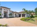 Beautiful home with a three-car garage, elegant entryway, landscaped yard, and a paver driveway at 3212 Signet Ct, Sarasota, FL 34240