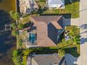 Aerial view of a charming single Gathering home featuring a screened in pool, lush tropical landscaping, and attached two car garage at 3415 Knox Ter, Port Charlotte, FL 33948