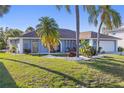 Beautiful single Gathering home with manicured lawn, lush tropical landscaping and an attached two car garage at 3415 Knox Ter, Port Charlotte, FL 33948