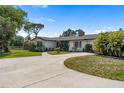 Charming single-story home showcasing a well-manicured lawn, mature trees, and a welcoming entrance at 3810 Hidden River Rd, Sarasota, FL 34240