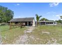 Property featuring a horse grazing in a fenced pasture near a stable and the main house at 3810 Hidden River Rd, Sarasota, FL 34240