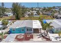 Eye-level view of quaint coastal home with car port, tropical landscaping and colorful exterior at 407 63Rd St, Holmes Beach, FL 34217