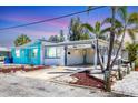 Charming coastal home featuring a carport, colorful accents, and tropical landscaping at 407 63Rd St, Holmes Beach, FL 34217