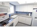 Well-lit kitchen with white cabinets and appliances, plus light countertops at 4154 Heron Way # 203B, Bradenton, FL 34205