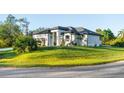 Beautiful single-story home with lush green lawn, well-maintained landscaping, and a stylish, modern design aesthetic at 5365 Craig Ter, Port Charlotte, FL 33981