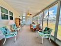 Bright sunroom with ample seating, ceiling fan, and large windows providing a tranquil view at 5511 Denmark Dr, Bradenton, FL 34207
